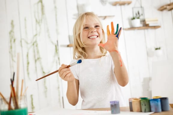 Child smiling while brushing her teeth