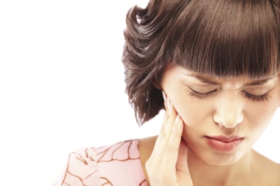 A patient touching a sore jaw